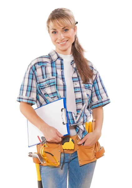 Beautiful young female worker with construction tools holding cl — Stock Photo, Image