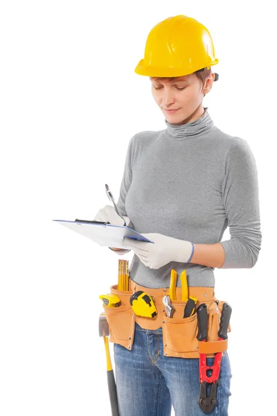 Trabalhador feamale com ferramentas de construção segurando prancheta escrita — Fotografia de Stock