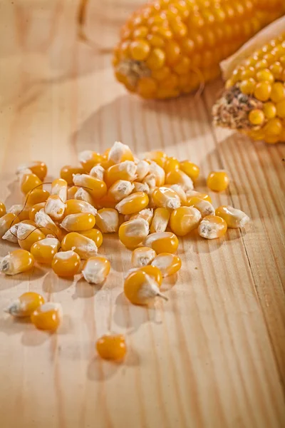 Corn and ear of corns on wooden table — Stock Photo, Image