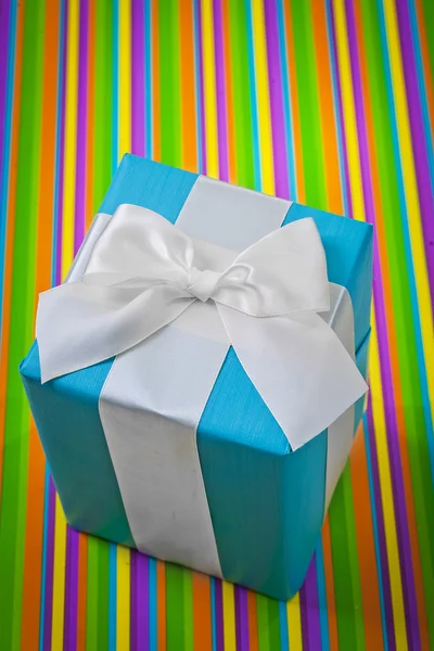 Caja de regalo clásica sobre fondo rayado de color — Foto de Stock