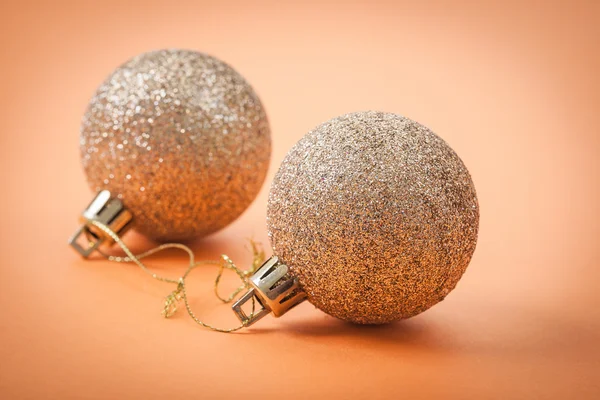 Gold christmas baubles on light brown background — Stock Photo, Image