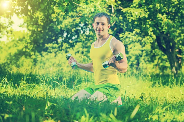 Sportif soulevant des poids dans le parc — Photo