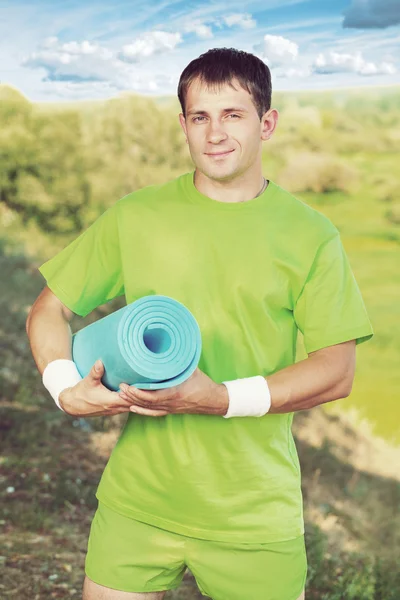 Sportsman in possesso di tappetino yoga — Foto Stock