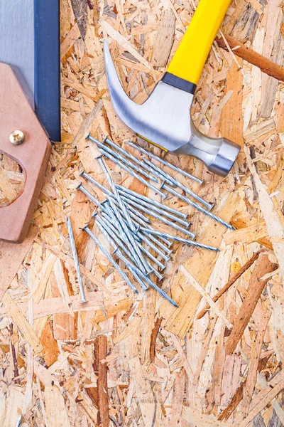 Klauenhammer mit Handsäge und Nägeln auf Sperrholz — Stockfoto