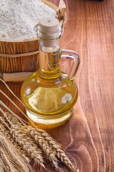 Bottle of oil with spoon and wheat — Stock Photo, Image