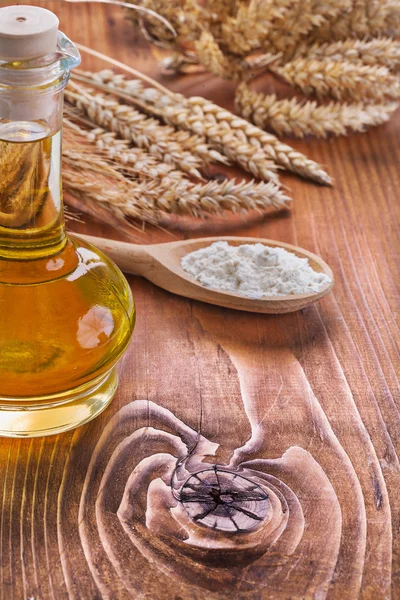 Bottle of oil with spoon and wheat — Stock Photo, Image