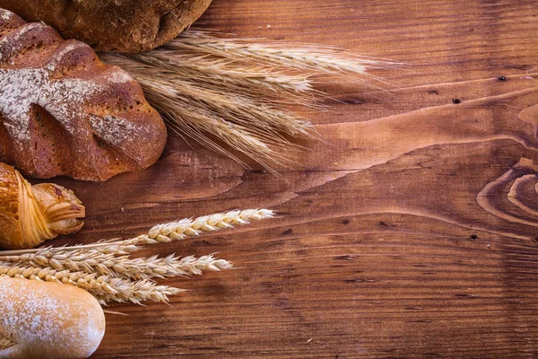 Loafs of bread and wheat ears — Stock Photo, Image