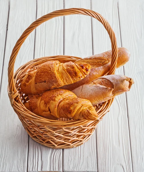 Baguette und Croissants im Korb — Stockfoto