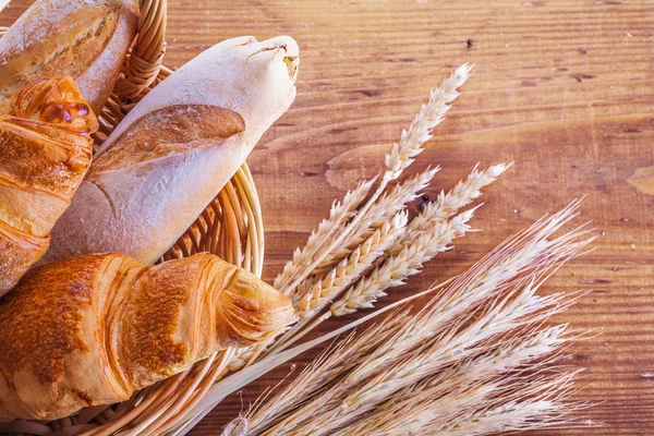 Baguetes e croissants em cesta de vime — Fotografia de Stock