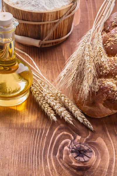 Ears of wheat and loaf of sweet bun — Stock Photo, Image