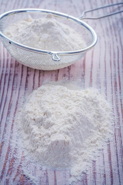 Flour and sieve on wooden board — Stock Photo, Image