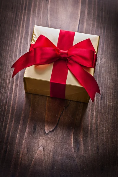 Goldene Geschenkbox mit roter Schleife — Stockfoto