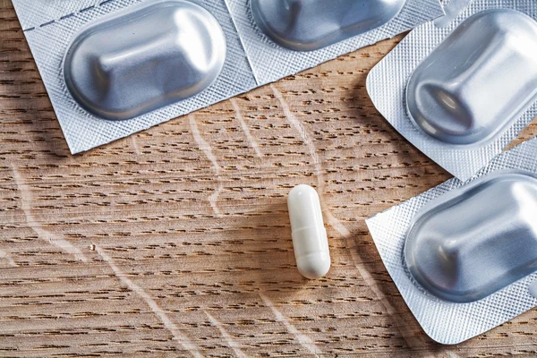 Pills on wooden board — Stock Photo, Image