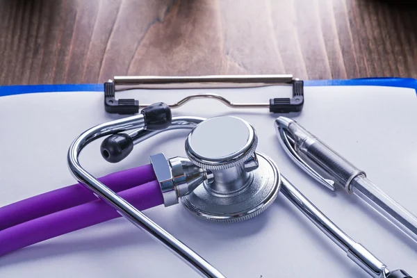Stethoscope with purple tubes and ballpoint pen — Stock Photo, Image