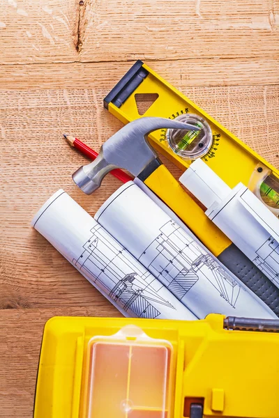 Rolled blueprints and hammer on wooden board — Stock Photo, Image