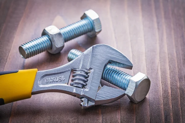 Wrench and bolts on wooden board — Stock Photo, Image