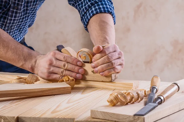 Händerna på snickare med träarbetare plan — Stockfoto