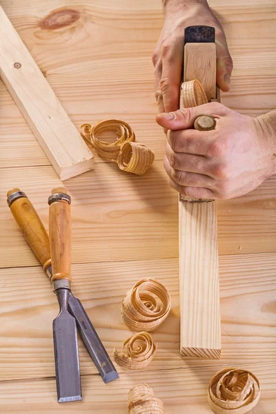 Hands of carpenter with woodworkers plane — Stock Photo, Image