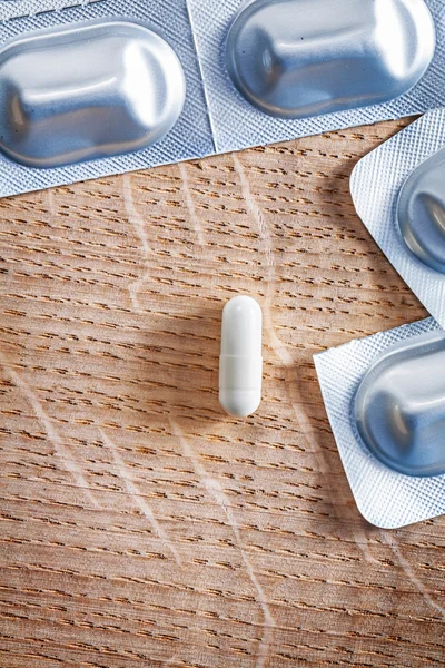 Blister with  pills on wooden board — Stock Photo, Image