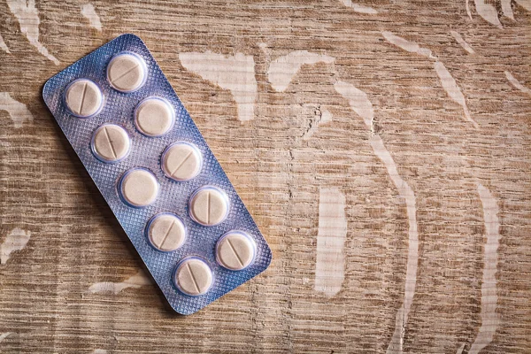 Blister with  pills on wooden board — Stock Photo, Image
