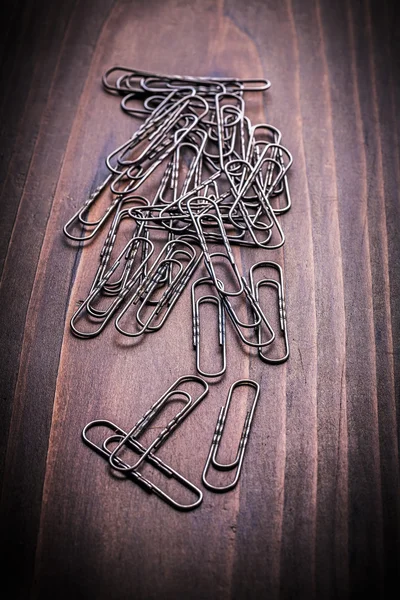 Paperclips on vintage wooden board — Stock Photo, Image