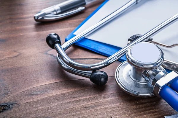 Stethoscope clipboard on vintage wooden board — Stock Photo, Image