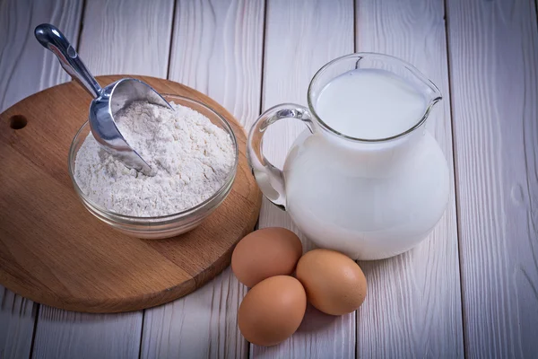 Flour, eggs, pitcher with milk — Stock Photo, Image