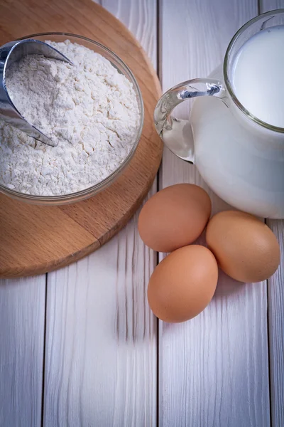 Flour, eggs, pitcher with milk