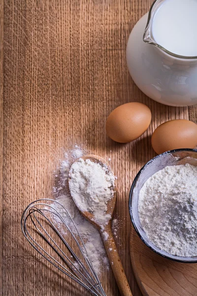 Pitcher with milk, eggs and flour in bow — Stock Photo, Image