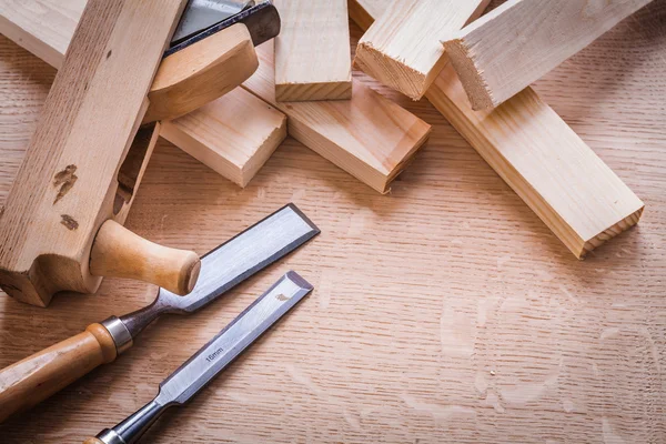 Chisels and planks on wooden board — Stock Photo, Image