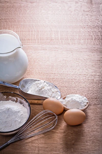 Flour in spoon bowl and eggs corolla — Stock Photo, Image