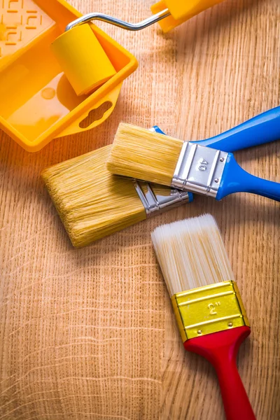 Paint brushes and tray on wooden board — Stock Photo, Image