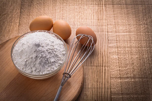 Flour in bowl on wooden board — Stock Photo, Image