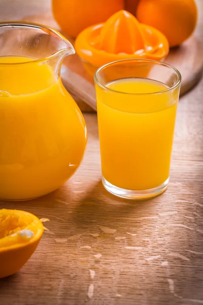 Suco e laranjas com espremedor — Fotografia de Stock