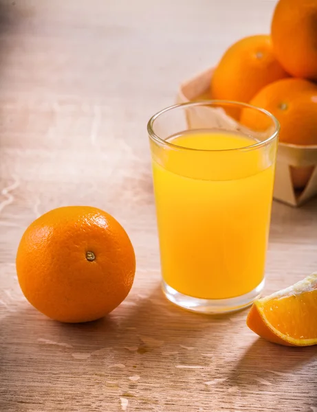 Glass with juice on wooden board — Stock Photo, Image