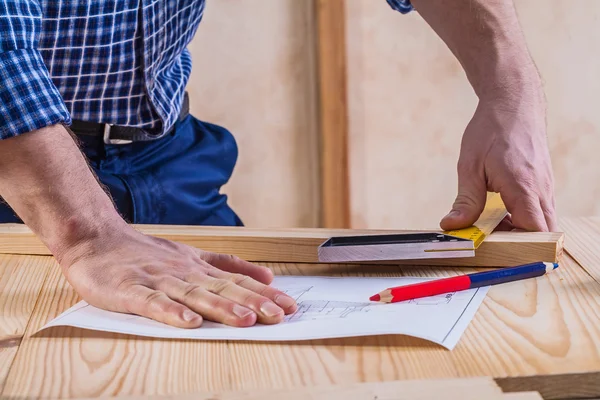 Hands of carpenter on table with blueprint — Stock Photo, Image