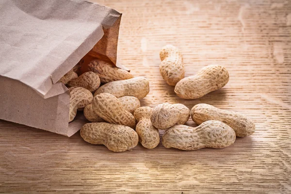 Peanuts poured from paper bag — Stock Photo, Image