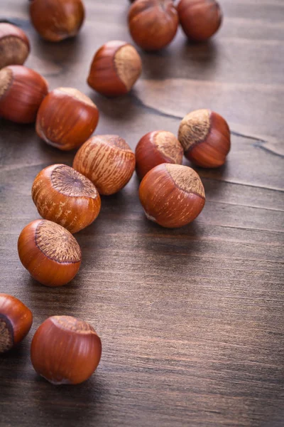 Several hazelnuts on wooden board — Stock Photo, Image