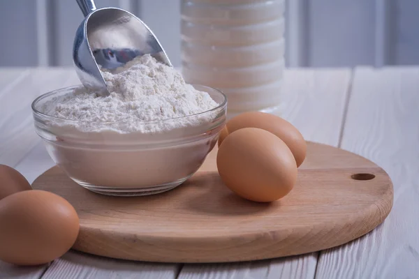 Flour in bowl on old wooden board — Stock Photo, Image