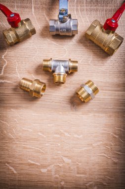 Brass Pipe Connectors On Wooden Board clipart