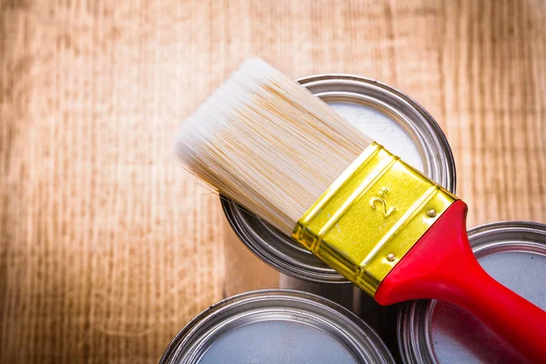 Paint brush on three cans — Stock Photo, Image