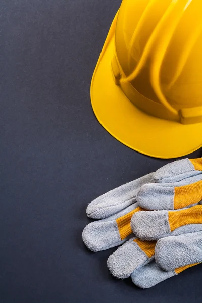 Beschermende werkhandschoenen en gele helm — Stockfoto