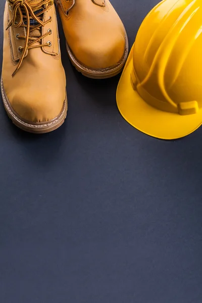 Capacete amarelo e botas de trabalho — Fotografia de Stock