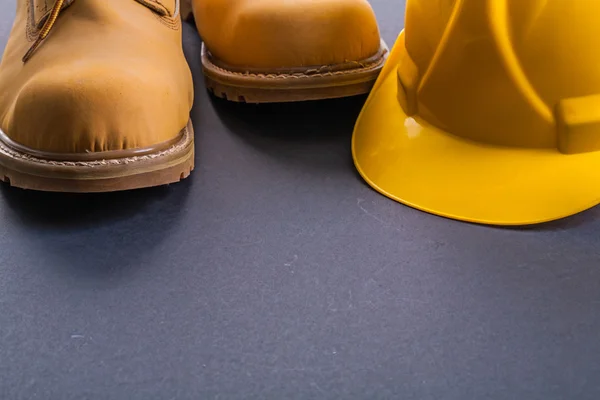 Botas de trabalho e capacete amarelo — Fotografia de Stock