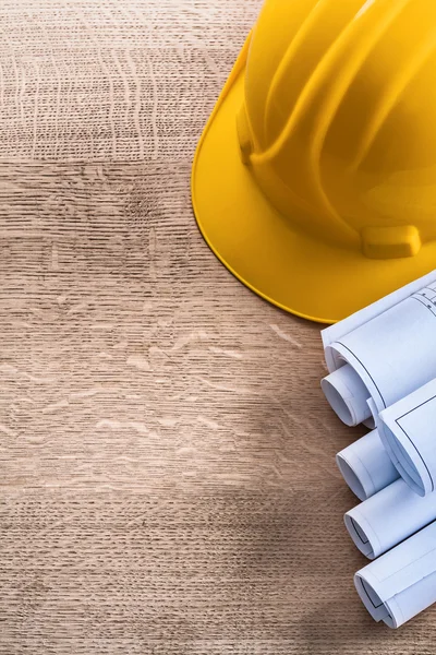 Construction helmet and blueprint rolls — Stock Photo, Image