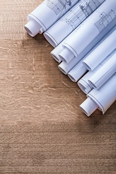 Rolls of blueprints on wooden board — Stock Photo, Image
