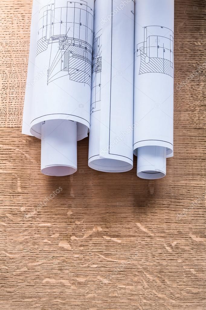 Rolls of blueprints on wooden board