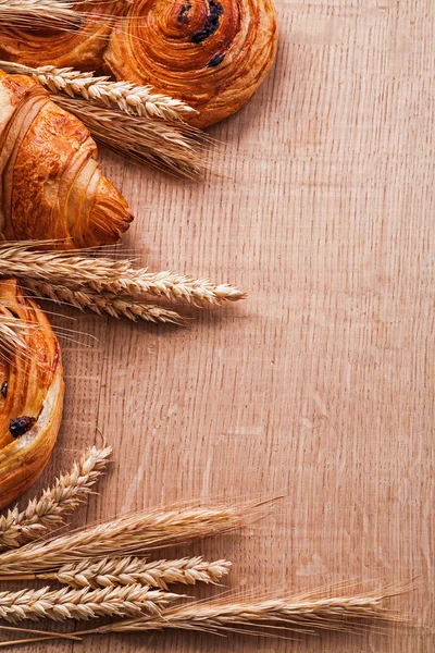 Weizenähren, Croissants mit Rosinen — Stockfoto
