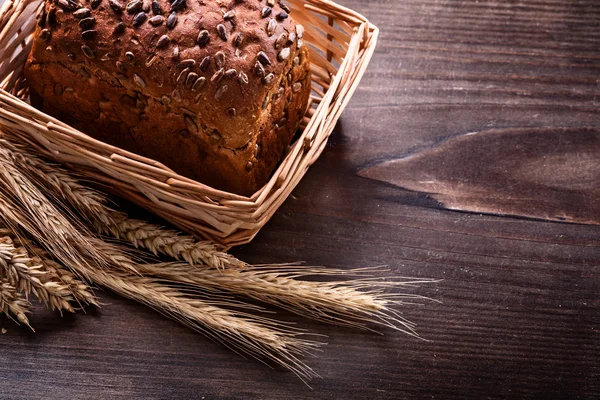 Pão crocante com sementes em cesta de vime — Fotografia de Stock