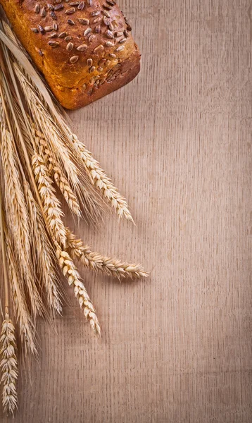 Коричневый хлеб с пшеничными ушами — стоковое фото